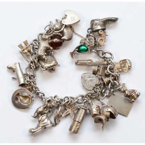 223 - A silver heart padlock clasp charm bracelet with charms, to include a ball and claw example, 87gm.