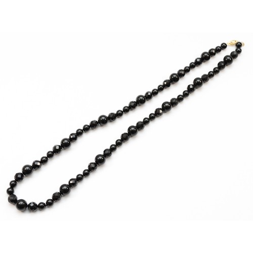 226 - A 14k gold clasped onyx beaded necklace, 66cm.