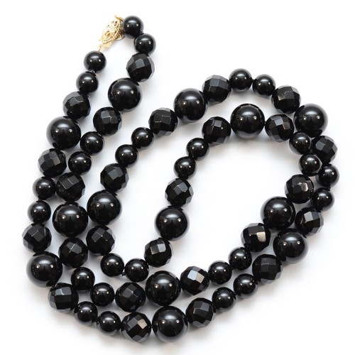 226 - A 14k gold clasped onyx beaded necklace, 66cm.