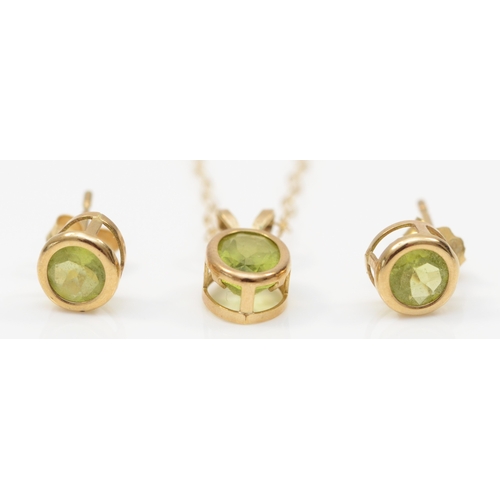 369 - A 9k gold peridot pendant, on a 375 gold chain, 12mm, together with a pair of unmarked gold peridot ... 