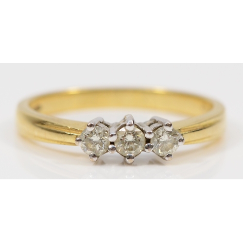 406 - An 18ct gold three stone brilliant cut diamond dress ring, Q, 3.8gm.