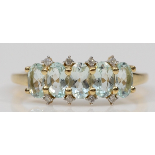 462 - A 9ct gold five stone aquamarine dress ring, with eight cut diamond accents, M, 1.7gm.