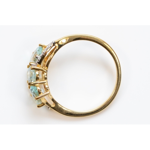 463 - A 9ct gold three stone aquamarine dress ring, with eight cut diamond shoulders, O, 2gm.