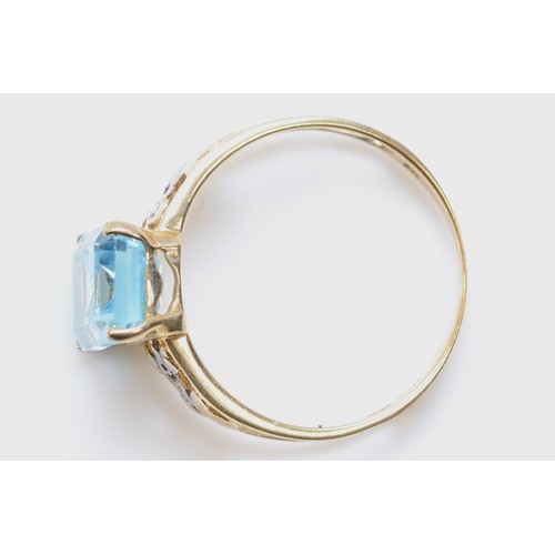 496 - A 9k gold blue topaz dress ring, with eight cut diamond shoulders, O-P, 1.7gm.