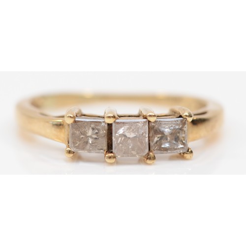 498 - A 10k gold three stone square cut diamond dress ring, O, 1.9gm.