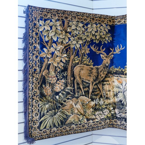 87 - A woven wall hanging featuring deer. 190 x 125cm. 
Together with a similar wall hanging featuring a ... 