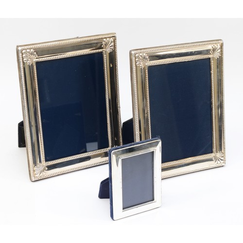 A pair of silver phootograph frames, Sheffield 1994, with embossed decoration, 22 x 17cm and another frame.
