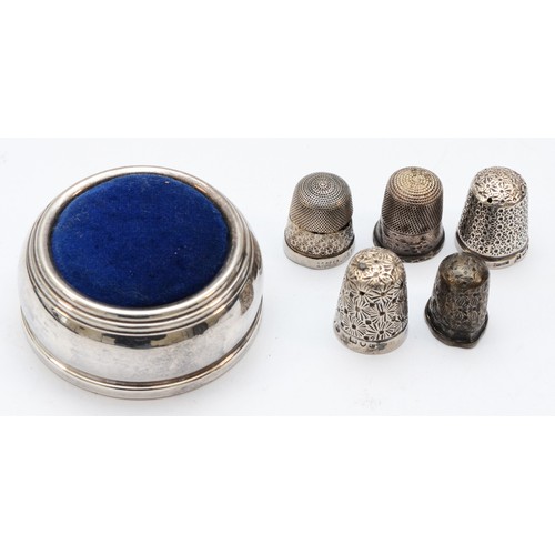 86 - A silver pin cushion, Birmingham 1995, four silver thimbles and a Sterling Silver example