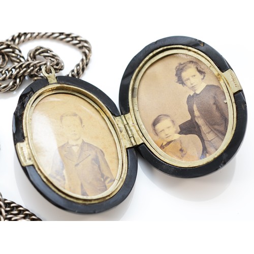 196 - A Victorian oval Jet locket, with metal internal fittings, 49 x 38mm, to an unmarked 66cm silver cha... 