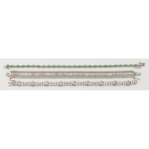 201 - A silver and emerald set line bracelet, 20cm, and two other white stone set silver bracelets, 52gm