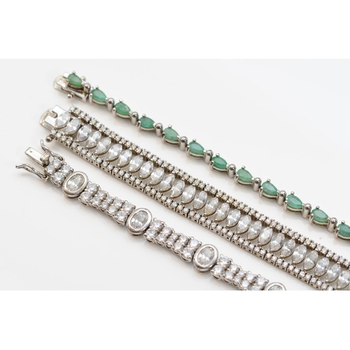 201 - A silver and emerald set line bracelet, 20cm, and two other white stone set silver bracelets, 52gm