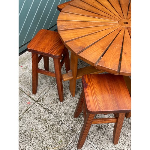 4 - A child's pine garden table, 90cm diameter with six matching pine stools and a drum BBQ.