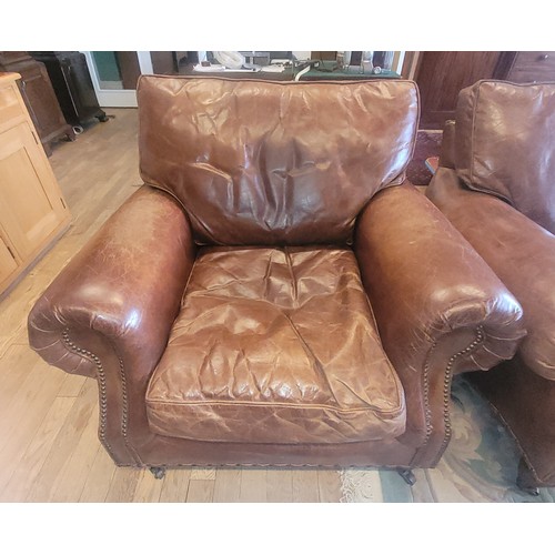 393 - A contemporary two seater sofa upholstered in a grain tan hide leather, having drop in cushioned bac... 