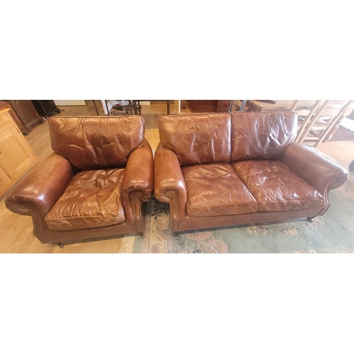 393 - A contemporary two seater sofa upholstered in a grain tan hide leather, having drop in cushioned bac... 