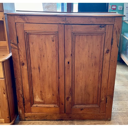 394 - A late 19th century pitch pine kitchen cabinet, the twin panelled doors opening to reveal two fitted... 