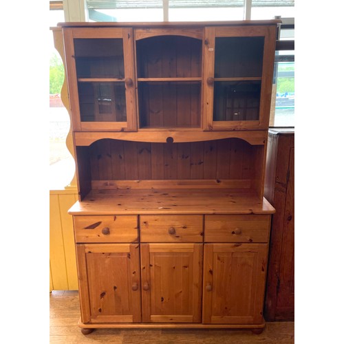 395 - A traditional pine dresser, the rack fitted with central shelf flanked by glazed cupboards, the base... 