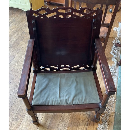 396 - An oak fireside or chimney armchair, circa 1930s, with slatted back and bowed leather seat, the carv... 