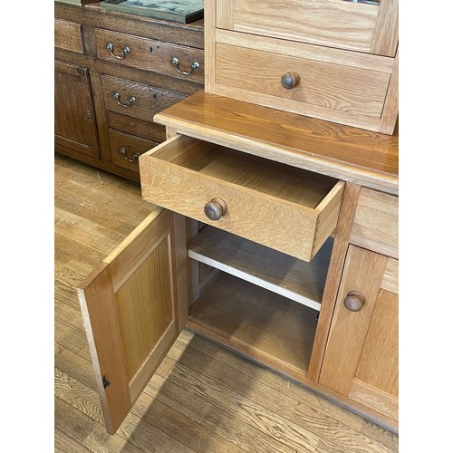 397 - A modern light oak kitchen dresser,the flared cavetto cornice over a central bank of three fitted op... 