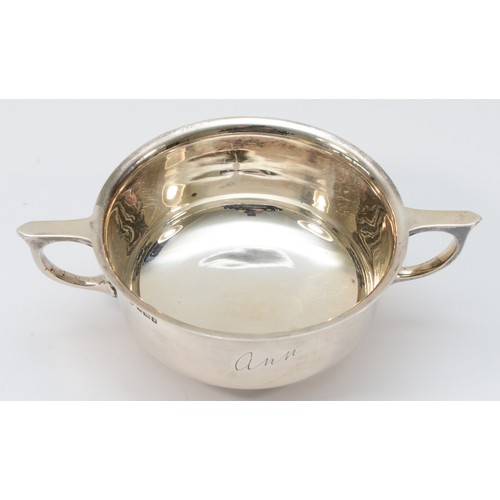 21 - A silver two handled porringer, Sheffield 1915, engraved Ann, 17.5cm across the handles, 255gm