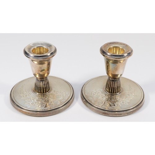 23 - A silver pair of desk candlestick's, Birmingham 1961, with engine turned and engraved floral decorat... 