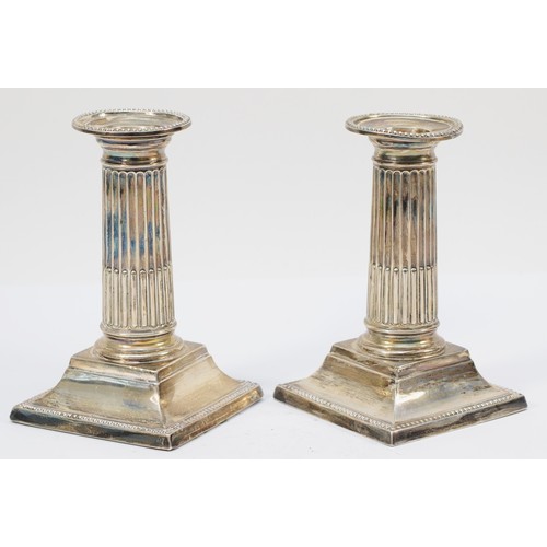 33 - A Victorian silver pair of short Corinthian column candlesticks, Sheffield 1898, with pull off sconc... 