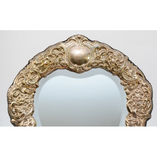 36 - A silver heart shaped bevelled easel mirror, Sheffield 1996, with embossed floral, bird and cherub d... 