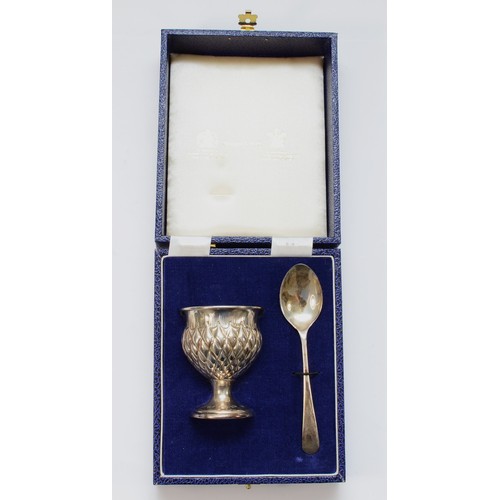 38 - A silver christening egg cup and spoon set, by Mappin & Webb, Birmingham 1986, of thistle form, unen... 