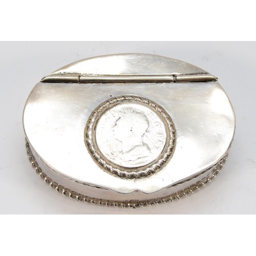 61 - An unmarked white metal oval snuff box, the hinged lid inset with a George IV coin, gadrooned border... 