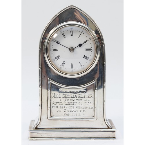 67 - An Edwardian silver presentation desk clock, Birmingham 1907, of arched form, white enamel dial with... 