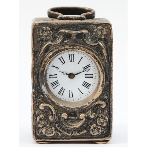 68 - A Victorian silver miniature timepiece, London 1891, with embossed decoration and swing handle, rais... 