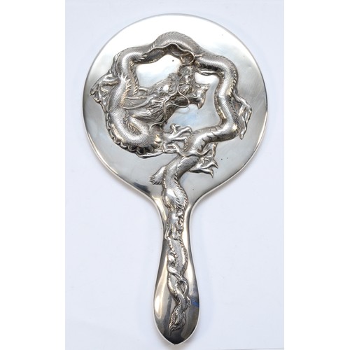 55 - A Chinese silver hand mirror, by Wing Nam & Co, Hong Kong, c.1900/10, with applied four claw dragon,... 