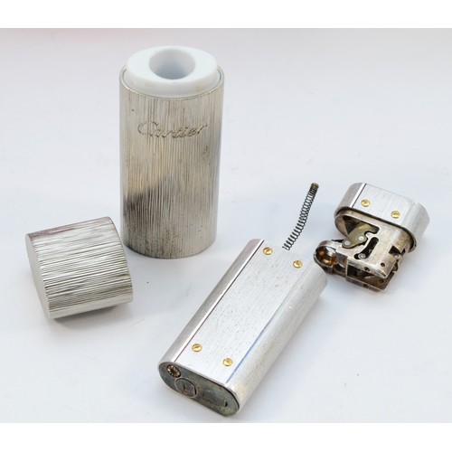 80 - Cartier, a brushed stainless steel and gold screw gas lighter, numbered E 72746, dismantled, case, w... 