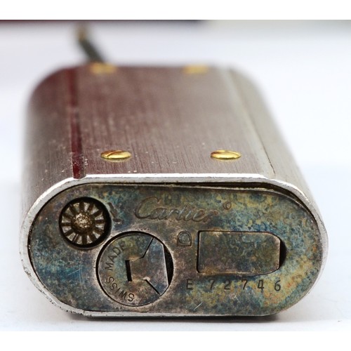 80 - Cartier, a brushed stainless steel and gold screw gas lighter, numbered E 72746, dismantled, case, w... 