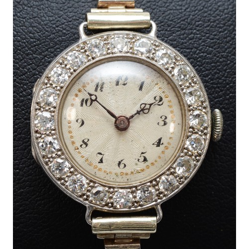 A platinum and diamond maual wind ladies wristwatch, c.1930's, silvered dial with Arabic numerals, unsigned 15 jewel, 6 adjustment Swiss movement, the bezel set with twenty old cut brilliant stones, total weight approximately 2.8cts, engraved back cover, to a later 9ct white gold bracelet, Birmingham 1955, weight without the movement 21.6gm.