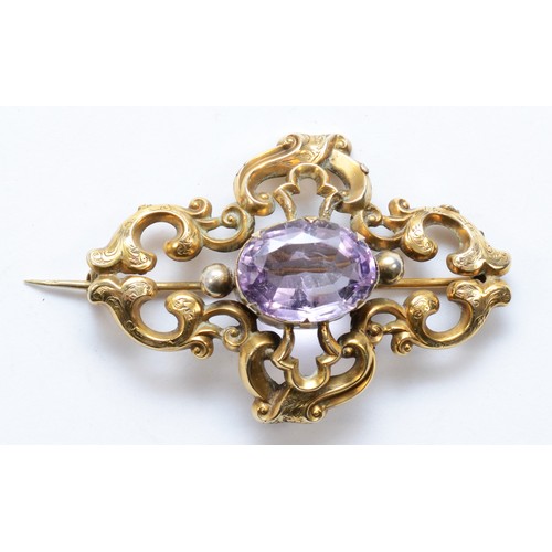 115 - A Victorian unmarked gold and amethyst brooch, with chased foliate scroll frame, 60 x 40mm, 12gm.