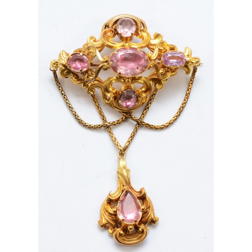 A Victorian unmarked gold foiled pink gemstone drop brooch, with foliate scroll frame and swag chain decoration, 77 x 50mm, 12.5gm.