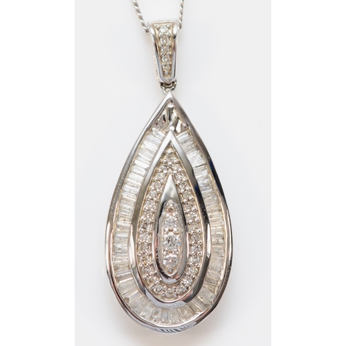 129 - A 9ct white gold and diamond pear shape pendant, set with three brilliants, bordered by single cuts ... 