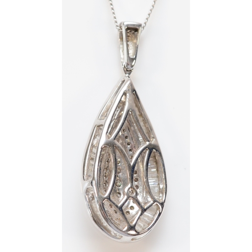 129 - A 9ct white gold and diamond pear shape pendant, set with three brilliants, bordered by single cuts ... 