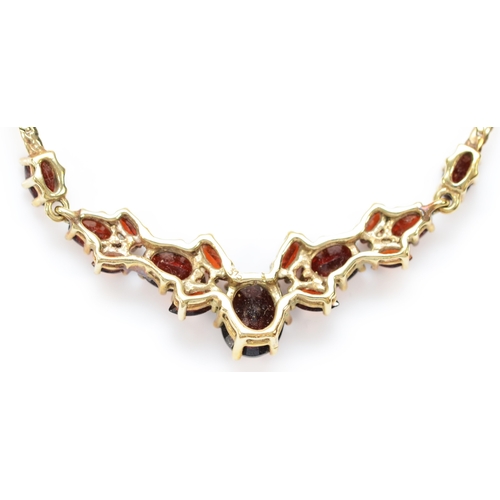 138 - A 9ct gold and graduated garnet panel front necklace, 48mm, to a flattened curb link chain42cm, 6.4g... 