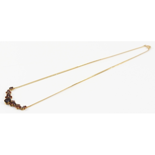 138 - A 9ct gold and graduated garnet panel front necklace, 48mm, to a flattened curb link chain42cm, 6.4g... 