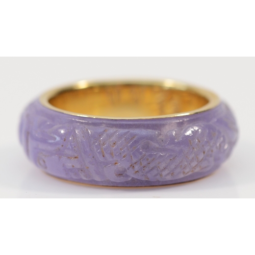 139 - A Chinese 14ct gold and enhanced carved lavender jadeite band ring, depicting two dragons chasing th... 