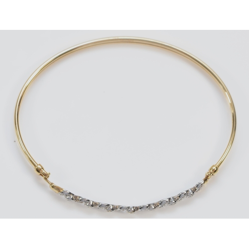 147 - A 9ct gold and diamond set sprung bangle, 65 x 51mm, 4.9gm