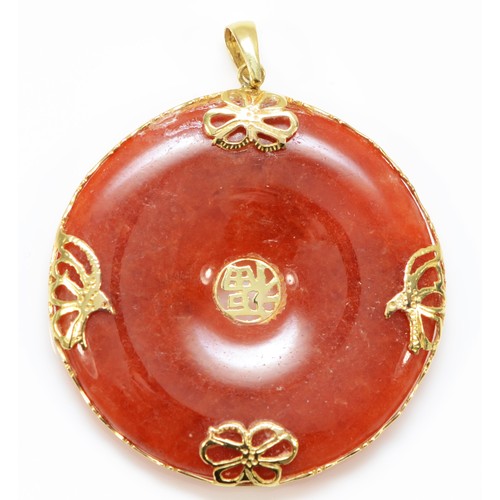 154 - A Chinese 14K gold mounted reddish/brown jadeite disc pendant, diameter 36mm