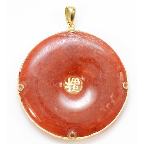 154 - A Chinese 14K gold mounted reddish/brown jadeite disc pendant, diameter 36mm