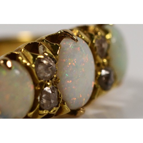 164 - An Edwardian 18ct gold three stone opal ring, old cut diamonds between, London 1915, S, 4gm