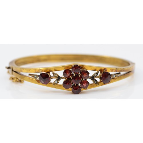 167 - A late 19th century gilt metal and Bohemian garnet cluster bangle, 57 x 47mm.