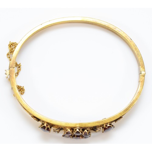 167 - A late 19th century gilt metal and Bohemian garnet cluster bangle, 57 x 47mm.