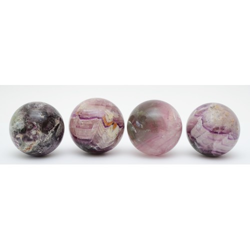 192 - A set of four Blue John balls, 62mm diameter