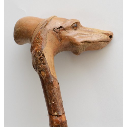 197 - A late 19th century carved fruitwood walking stick, the carved dogs head terminal with glass bead ey... 