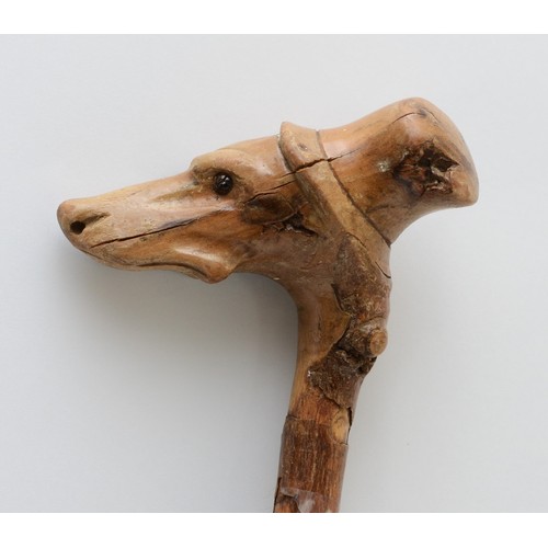 197 - A late 19th century carved fruitwood walking stick, the carved dogs head terminal with glass bead ey... 